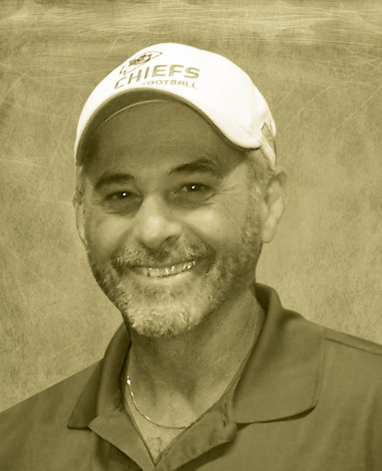 A man wearing a hat and smiling for the camera.
