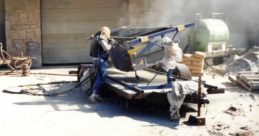 Two men working on a boat in the sun.