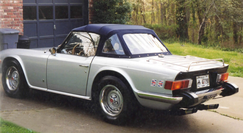 A silver car parked in the driveway of a house.