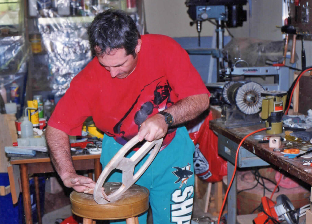 A man in red shirt holding a pair of scissors.
