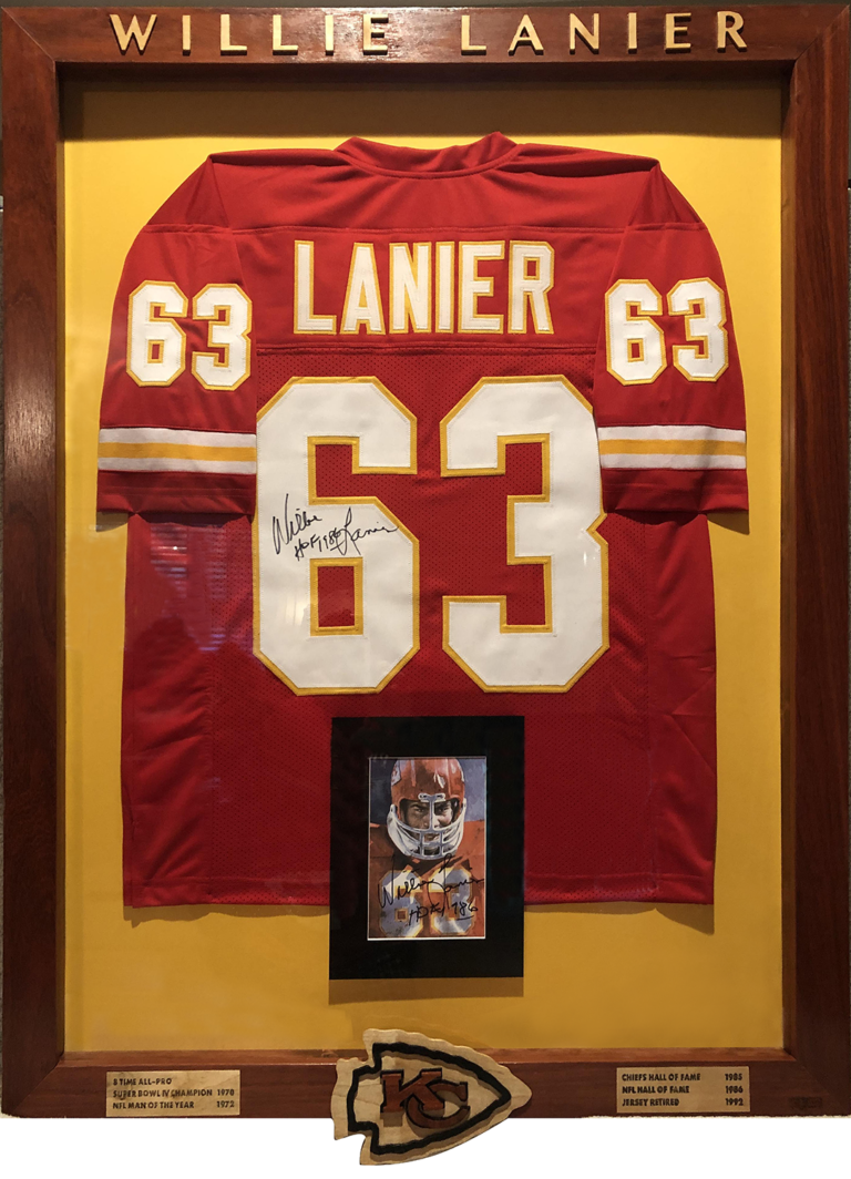 A framed jersey and picture of the kansas city chiefs football player.